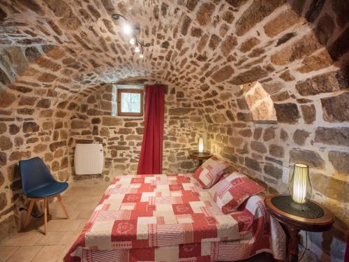 a bedroom with a bed in a stone wall at Detached holiday home in Chassiers with pool in Chassiers