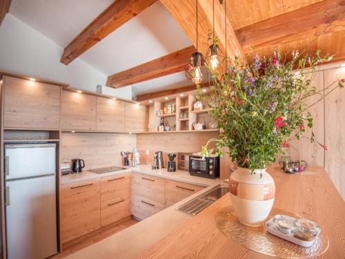 a kitchen with wooden cabinets and a vase with flowers at Detached holiday home in Chassiers with pool in Chassiers