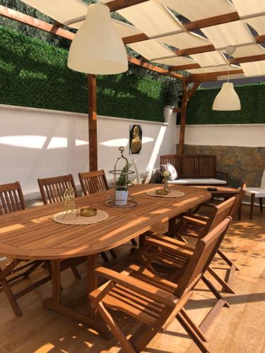 a wooden table with chairs and a large wooden at Ayshira Aparts in Kemer