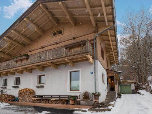 a house with a wooden roof in the snow at Modern Apartment in Kitzbuhel near Ski Area in Kitzbühel