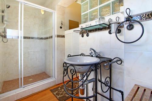 a bathroom with a shower and a sink at Atlantic Beach Villa in Cape Town