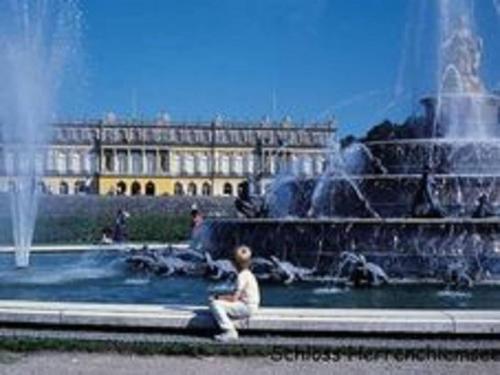 a young boy sitting in front of a fountain at Eco-friendly chalet near the lake in Asten in Tittmoning