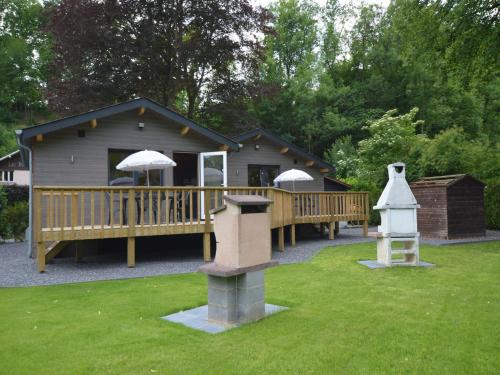 a house with a deck and a house with an umbrella at Scenic chalet in Vieuxville with terrace in Vieuxville