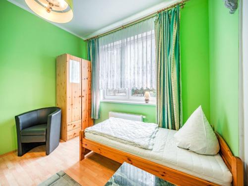 a bedroom with green walls and a bed and a chair at Deluxe Holiday Home in Brilon-Wald near Ski Area in Brilon