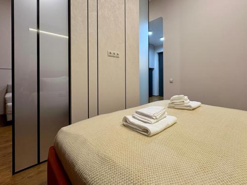 two folded towels sitting on a bed in a room at Siena Suite Tsaghkadzor in Tsaghkadzor