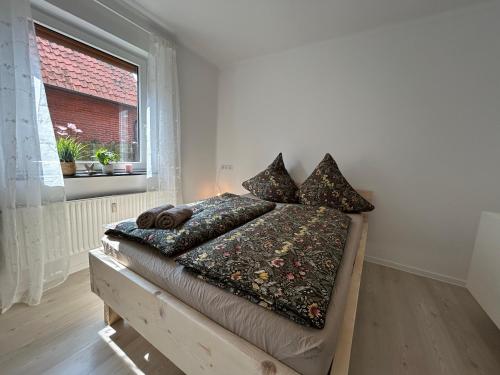 a bedroom with a bed with pillows and a window at Ferienwohnung Mimi in Steyerberg