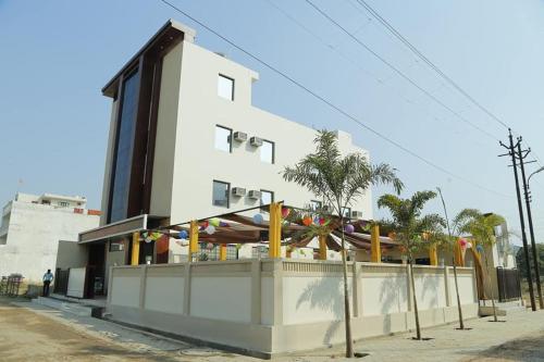 a white building with a fence in front of it at HOTEL GRAND SPARROW Inn in Agra