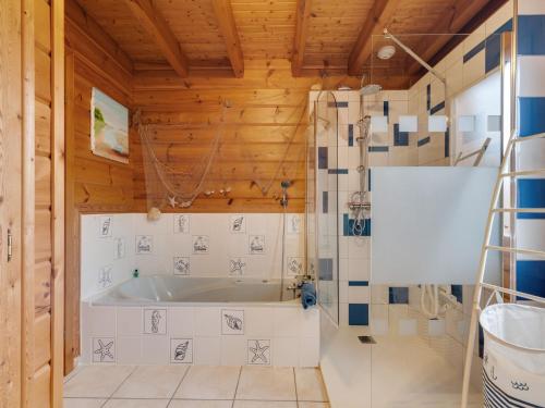 a bathroom with a tub and a wooden ceiling at Nature Chalet in Abbévillers in Abbévillers