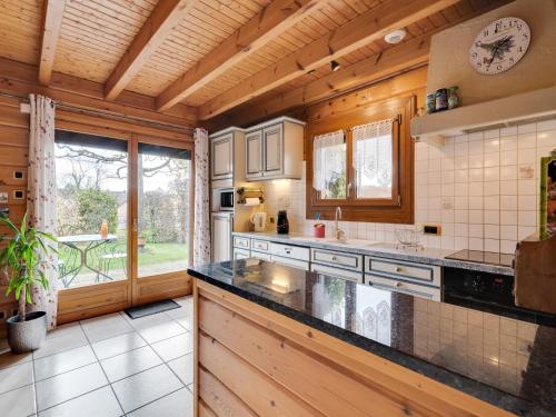 a kitchen with wooden walls and a large window at Nature Chalet in Abbévillers in Abbévillers