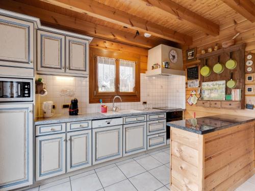 a large kitchen with wooden walls and wooden cabinets at Nature Chalet in Abbévillers in Abbévillers