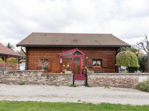 a small house with a red door on a stone wall at Nature Chalet in Abbévillers in Abbévillers