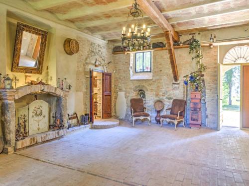 a living room with a fireplace and a chandelier at Farmhouse in Marsciano with vineyards olive groves in Marsciano