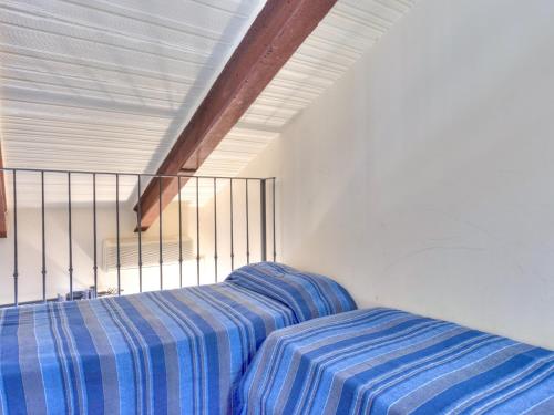 a bedroom with a bed with a blue striped sheets at Farmhouse in Marsciano with vineyards olive groves in Marsciano