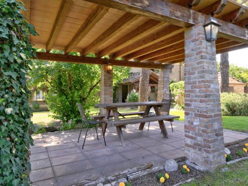 a patio with a wooden pergola and a picnic table at Farmhouse in Marsciano with vineyards olive groves in Marsciano