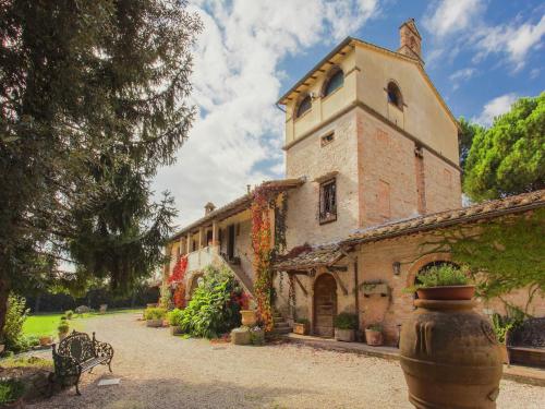 a building with a clock tower with a bench in front of it at Farmhouse in Marsciano with vineyards olive groves in Marsciano