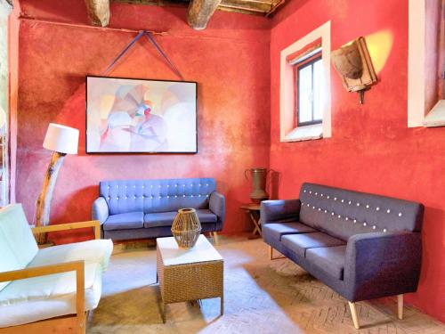 a living room with two blue couches and a red wall at Farmhouse in Marsciano with vineyards olive groves in Marsciano