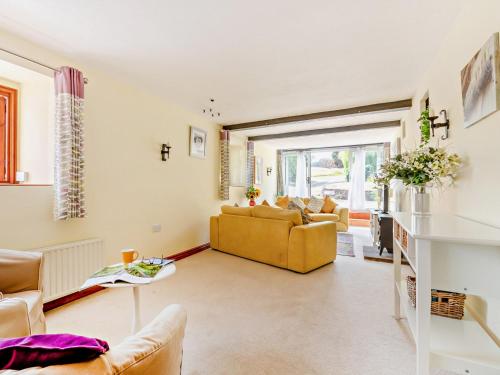 a living room with a yellow couch and a table at 3 Bed in West Quantoxhead 96235 in West Quantoxhead