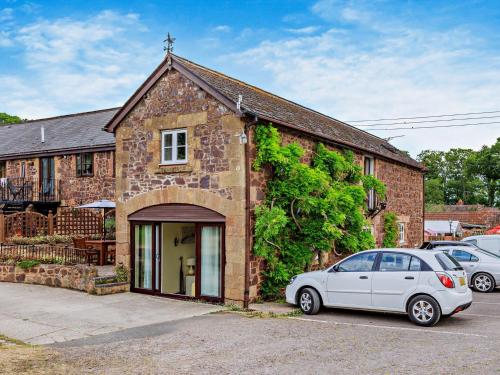 a white car parked in front of a brick building at 3 Bed in West Quantoxhead 96235 in West Quantoxhead