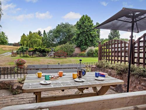 a wooden table with an umbrella and drinks on it at 3 Bed in West Quantoxhead 96235 in West Quantoxhead
