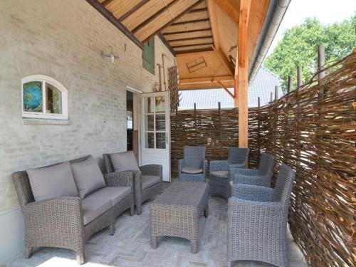 a patio with wicker chairs and tables and a fence at Pleasant Holiday Home near the centre of Haaren in Haaren