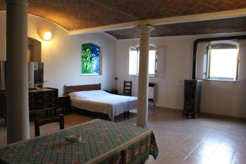 a bedroom with a bed and a table and windows at Agriturismo Lucchetta in Reggiolo