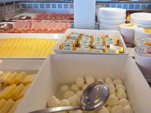 an open refrigerator with eggs and cheese and a spoon at Hotel Delle Nazioni - Adults Only in Caorle
