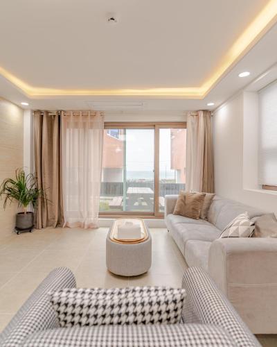 a living room with a couch and a table at Pool Story 6 in Jeju