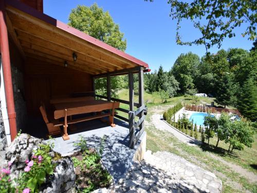 a building with a bench next to a swimming pool at Tranquil Holiday Home in Kvarner near Kupa River in Brod Moravice