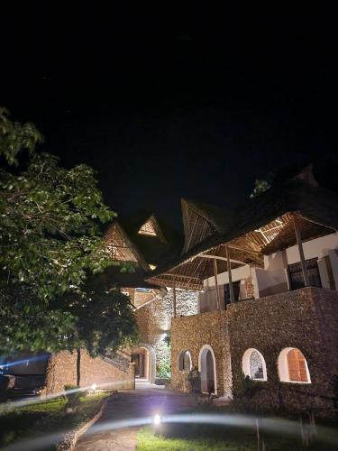 a building at night with lights on it at Mwazaro Beach Lodge in Shimoni