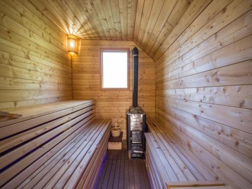 a wooden sauna with a stove in the middle at Tranquil Holiday Home in Kvarner near Kupa River in Brod Moravice
