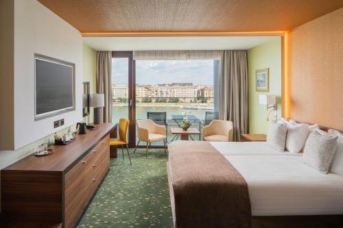 a hotel room with two beds and a television at Boutique Hotel Victoria Budapest in Budapest
