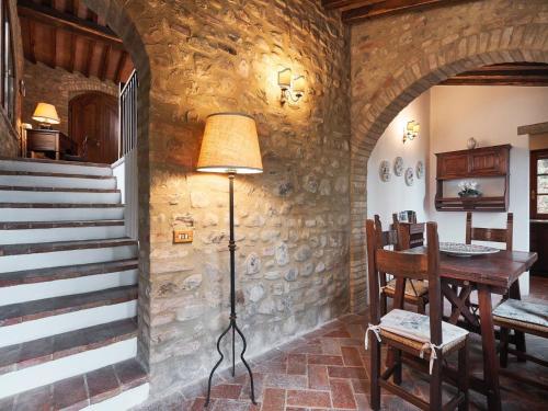 a room with a stone wall with a table and a lamp at Unique country house in an old hamlet in Monte Castelli