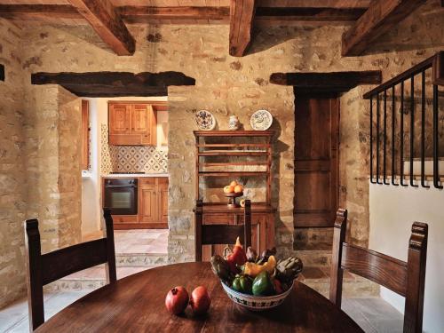 a kitchen with a wooden table with a bowl of fruit at Unique country house in an old hamlet in Monte Castelli