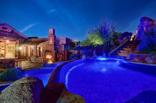 a swimming pool in a yard with a house at Castle On Black Mountain breathtaking panoramic views and outdoor entertainment in Cave Creek