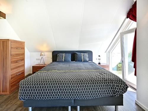 a bedroom with a bed and a large window at Chalet with gorgeous view of the natural surroundings in Weerselo