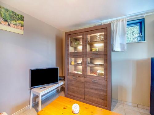 a living room with a tv and a wooden door at Test Property Sophisticated Holiday Home in Lierneux near forest in Lierneux