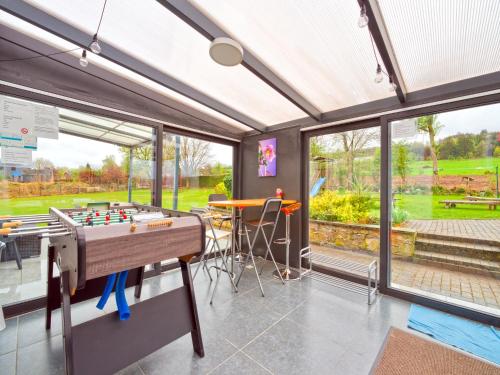 a room with a foosball table in front of windows at Test Property Sophisticated Holiday Home in Lierneux near forest in Lierneux