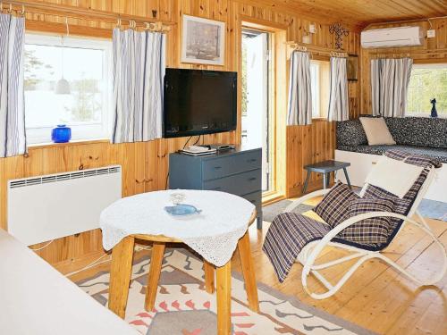a living room with a tv and a table and chairs at 4 person holiday home in Vetlanda in Lillarp