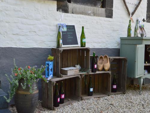 a shelf with bottles of wine and shoes next to a wall at Stunning Holiday Home near Forest in Slenaken in Slenaken