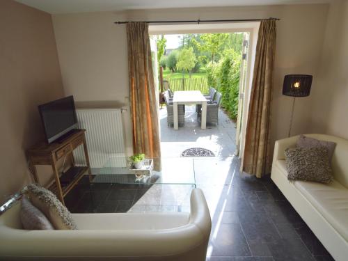 a living room with a tub and a patio with a table at Stunning Holiday Home near Forest in Slenaken in Slenaken
