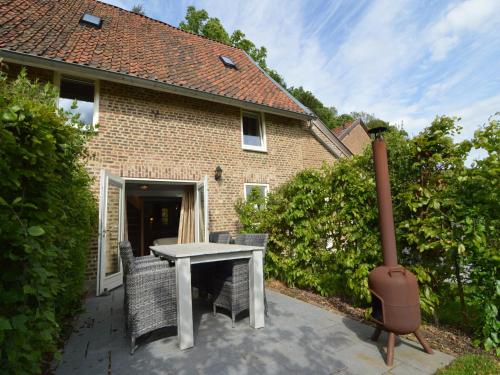 a patio with a table and chairs in front of a house at Stunning Holiday Home near Forest in Slenaken in Slenaken