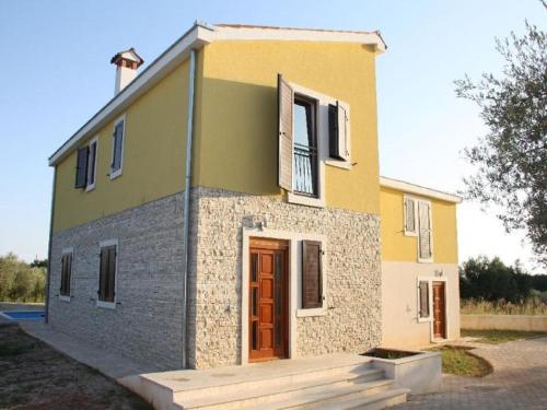 a small yellow and gray house with a wooden door at Splendid Holiday Home in Novigrad near sea in Novigrad Istria