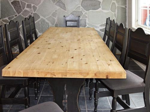 a wooden table with black chairs around it at 11 person holiday home in hebnes in Hebnes