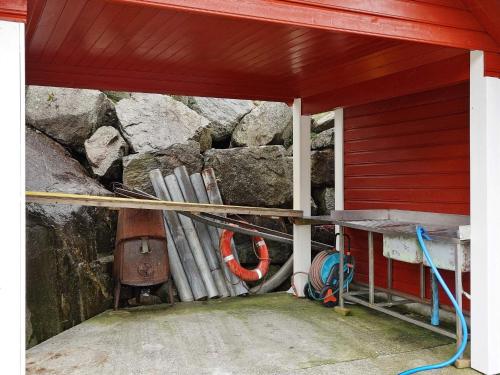 a red building with a stone wall and pipes at 11 person holiday home in hebnes in Hebnes