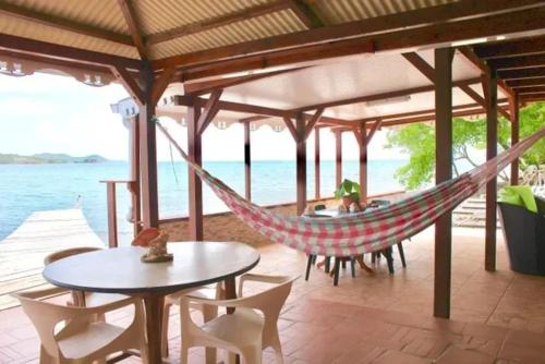 a hammock in a pavilion with a view of the ocean at Charmante maison face à la mer au François, 120 m² in Le François