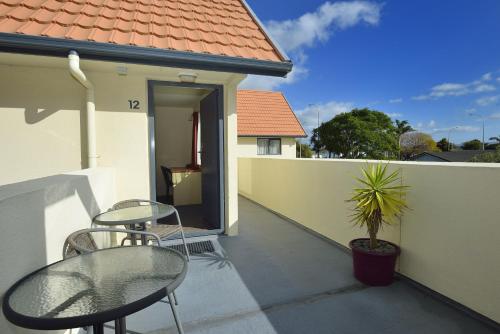 a patio with a table and chairs and a house at Bella Vista Gisborne in Gisborne
