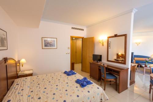 a bedroom with a bed and a desk and a mirror at Blue Horizon in Ialyssos