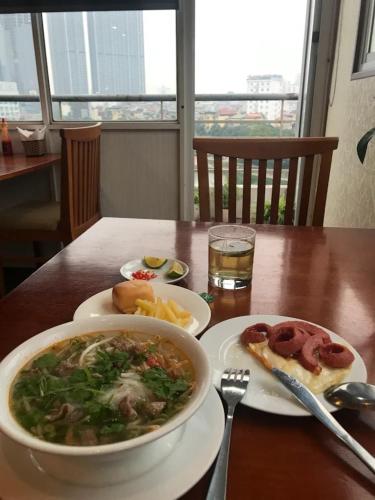a table with a bowl of soup and a plate of food at Regal Hotel Hà Nội in Hanoi