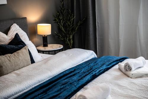 a bed with towels on it with a lamp on a table at 3 room apartment with balcony City center east in Mönchengladbach