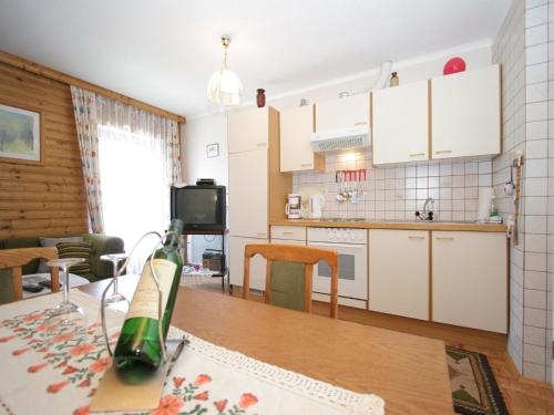 a kitchen and living room with a bottle on a table at Modern apartment with garden near the Petzen ski area in Eberndorf Carinthia in Eberndorf
